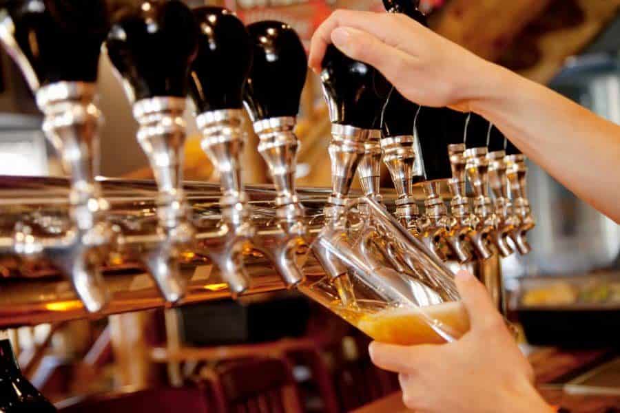 A bartender dispenses a beer from a beer tower