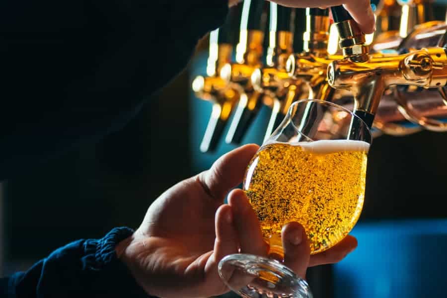 Bartender pouring draft beer into a glass