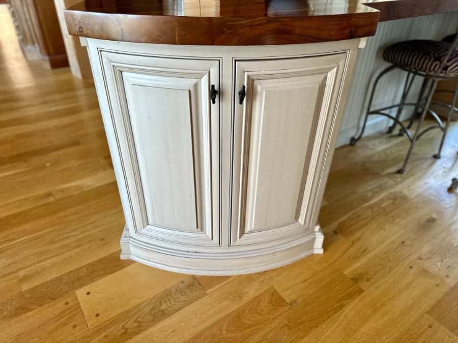 White cabinet holding keg in kitchen